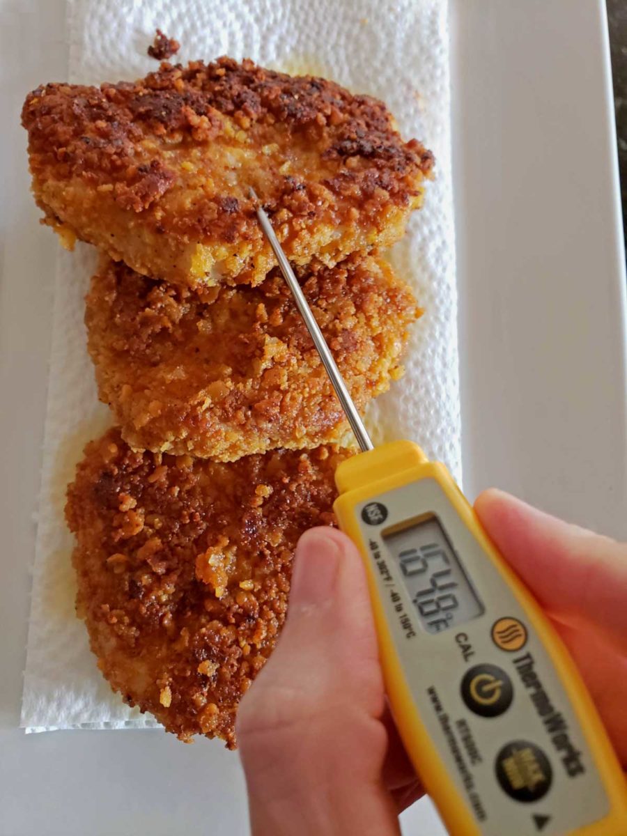pocket thermometer checking pork chop temperature