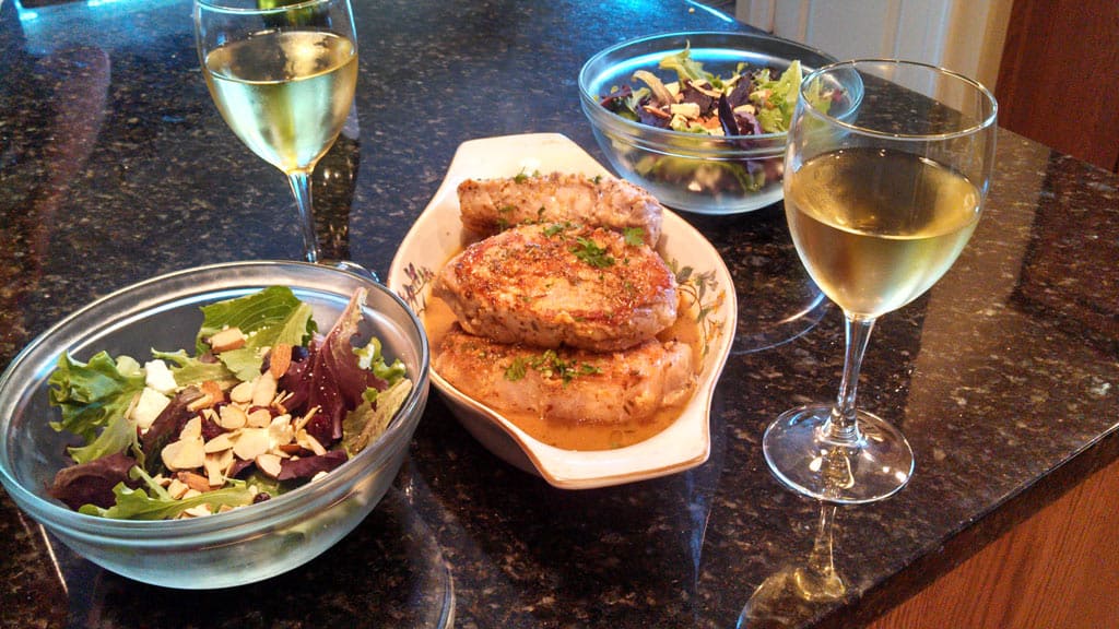 Sexy Pork Chops are smothered in a wonderful zesty sauce made of white wine, chicken broth, and garlic then finished off with lemon and fresh herbs. | TheMountainKitchen.com