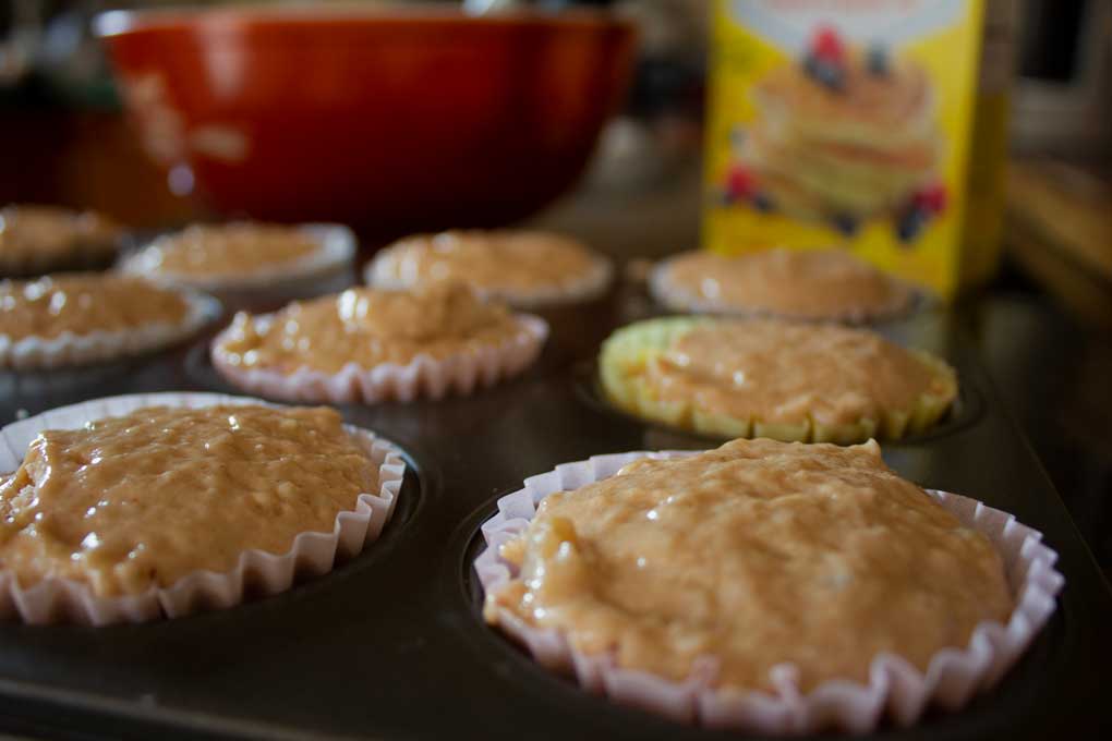 muffin tin with paper liners and muffin mix