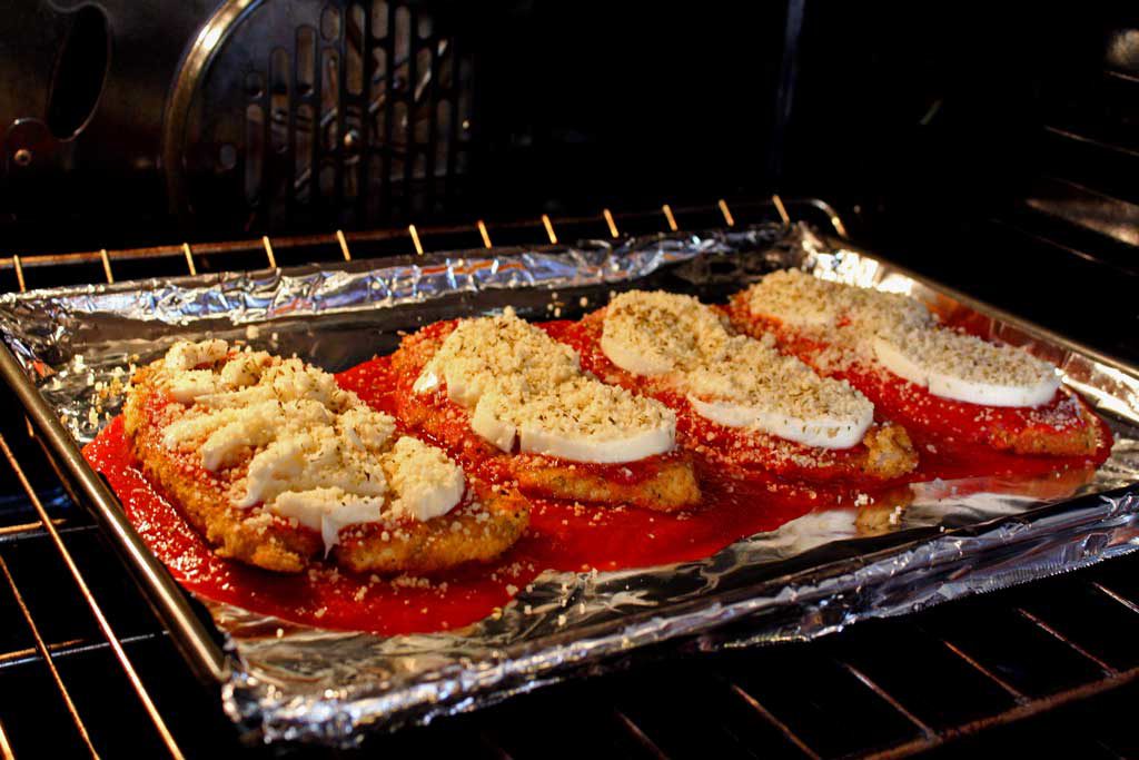 I practically drool just thinking about this delicious chicken parmesan. Lightly browned melted gooey cheese and fresh basil top these crispy breaded chicken breasts lying on a bed of tomato sauce with a side order of spaghetti. This is food that comforts the soul! | TheMountainKitchen.com