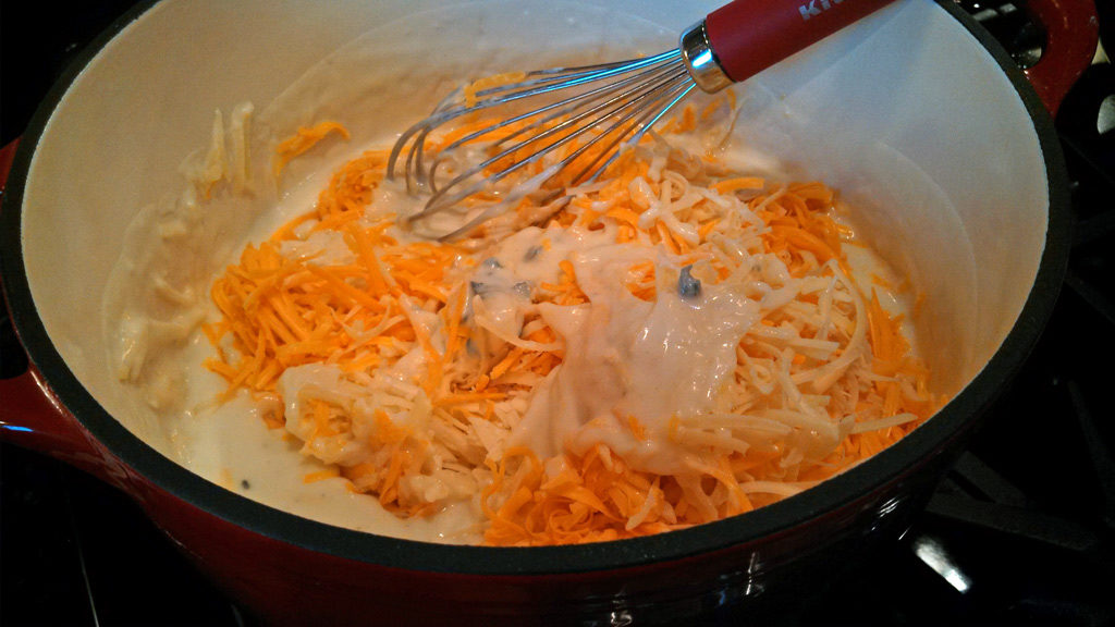 stirring the cheese into the pot