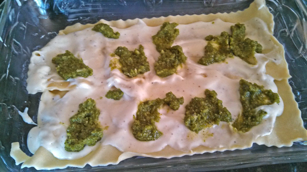 pesto dolloped onto sauce and noodles