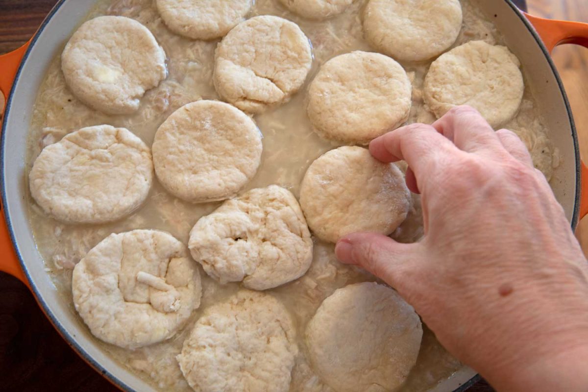 placing biscuits on top of chicken and rice