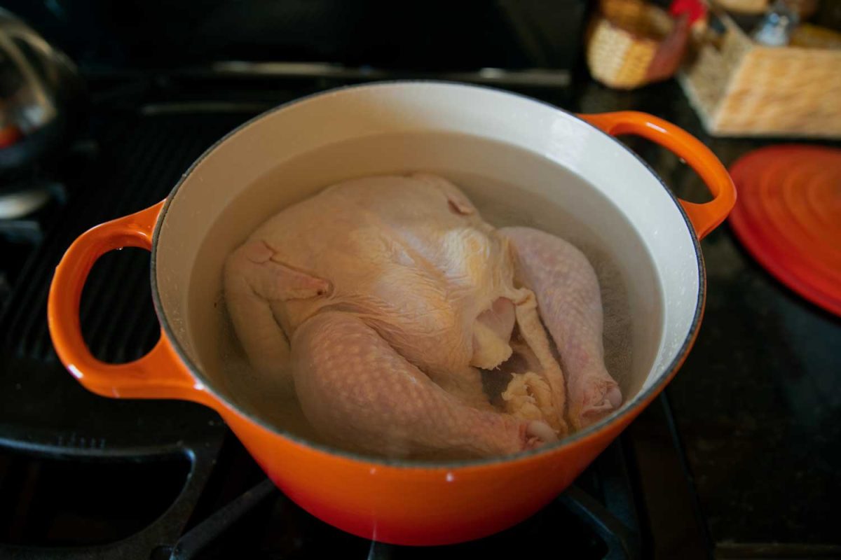 whole chicken in pot on the stove with water