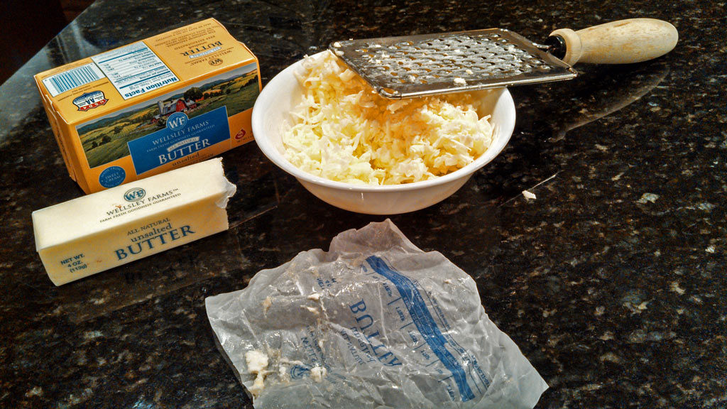 grating butter into a bowl