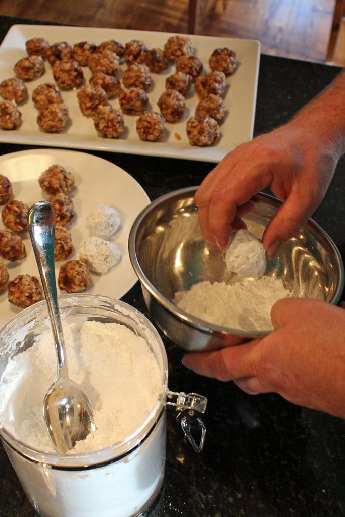 rolling the date nut balls in powdered sugar