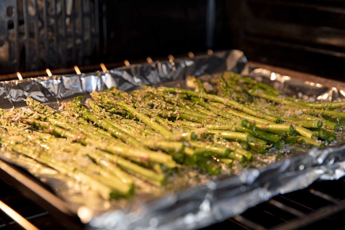 asparagus roasting on a sheet pan in a 400°F oven