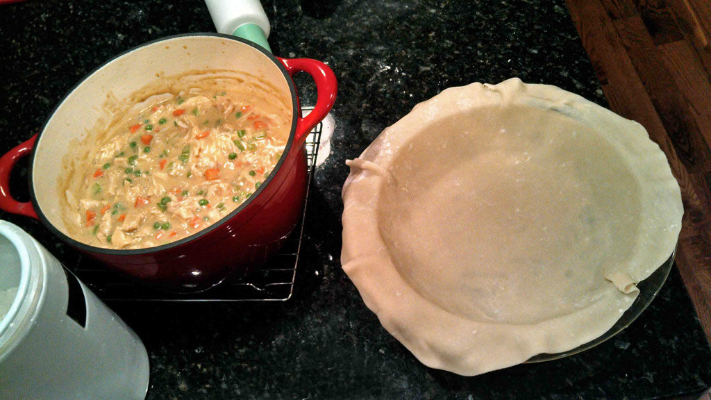 a pot of filling and pie crust in pie pan
