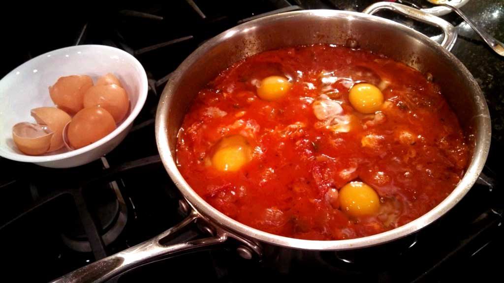 eggs cooking in tomato sauce