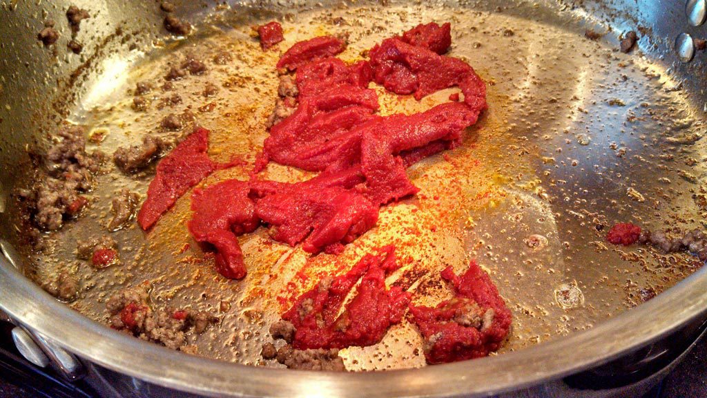 browning tomato paste in pan