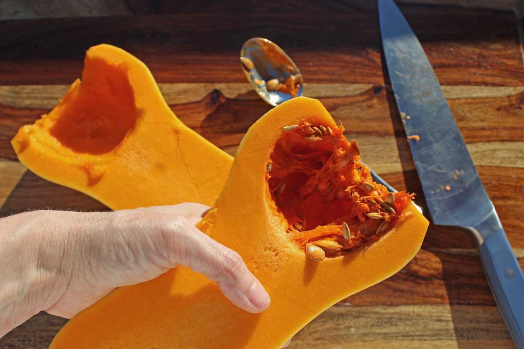 scooping out seeds of squash
