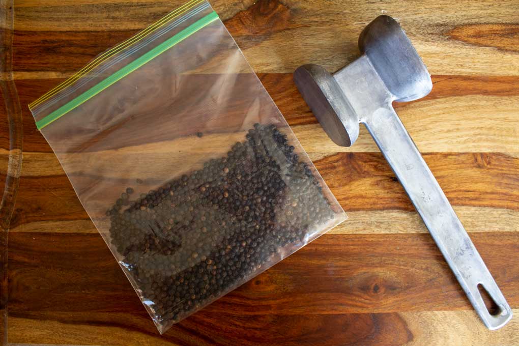peppercorns with mallet for lemon pepper seasoning