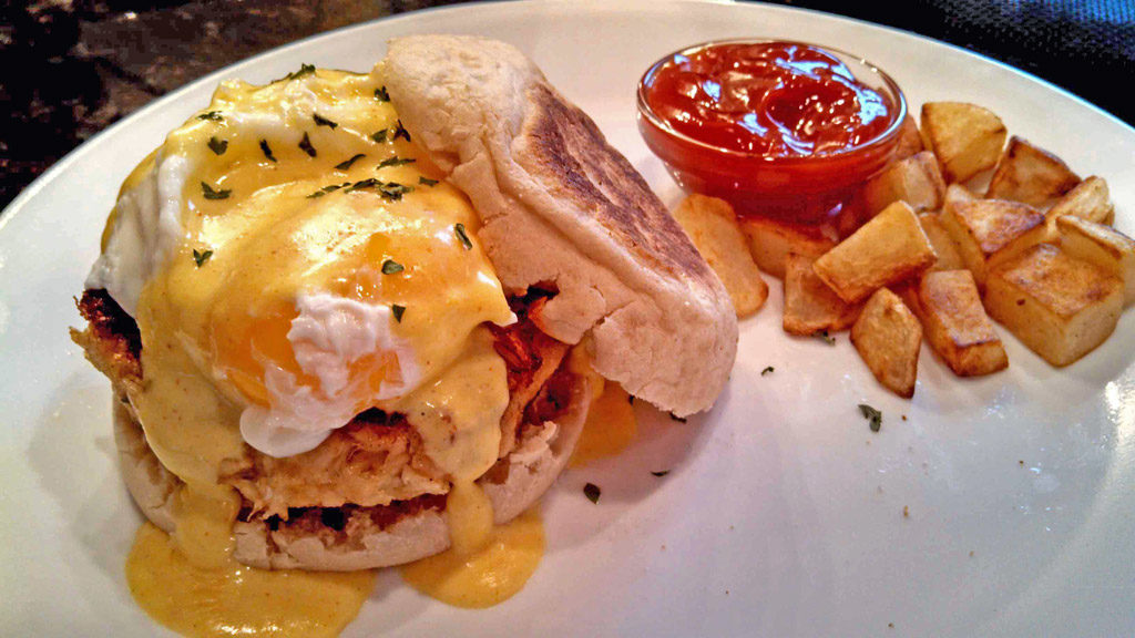 Crab Cakes Eggs Benedict with skillet potatoes on plate