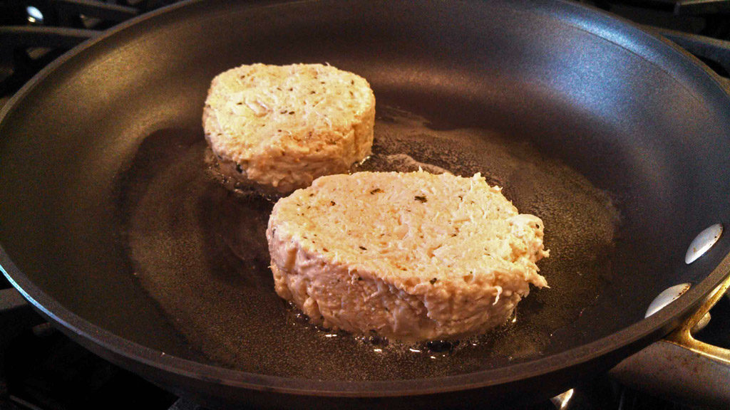 crab cakes cooking in skillet