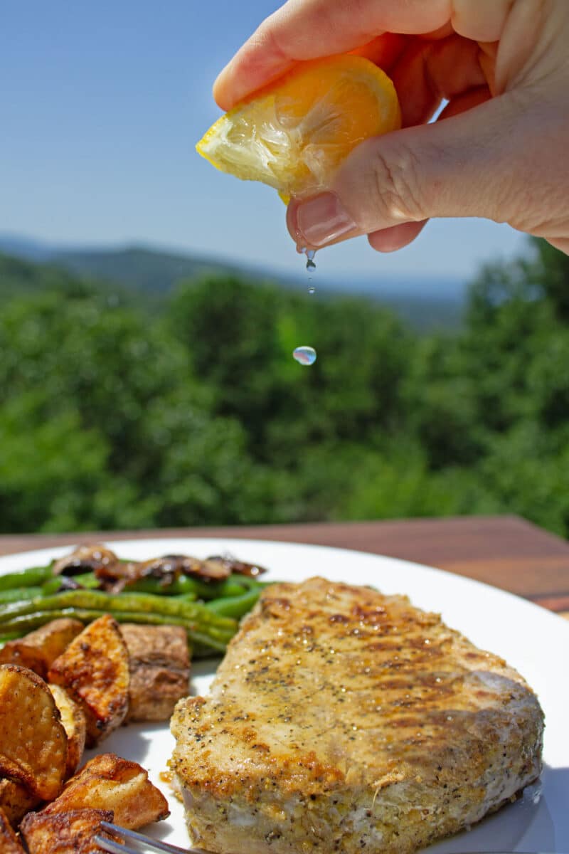 squeezing lemon juice onto tuna filet