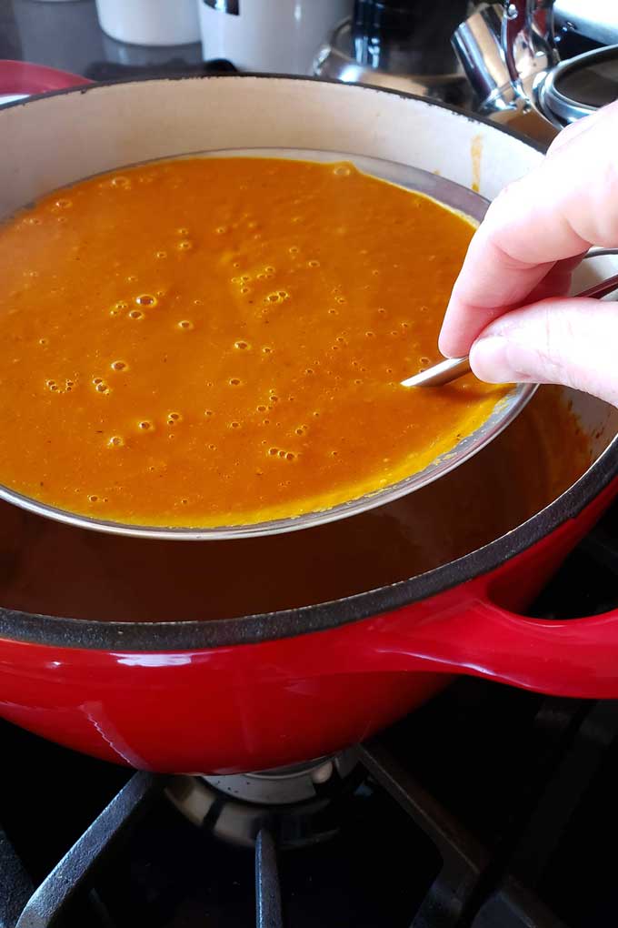 stirring soup through sieve
