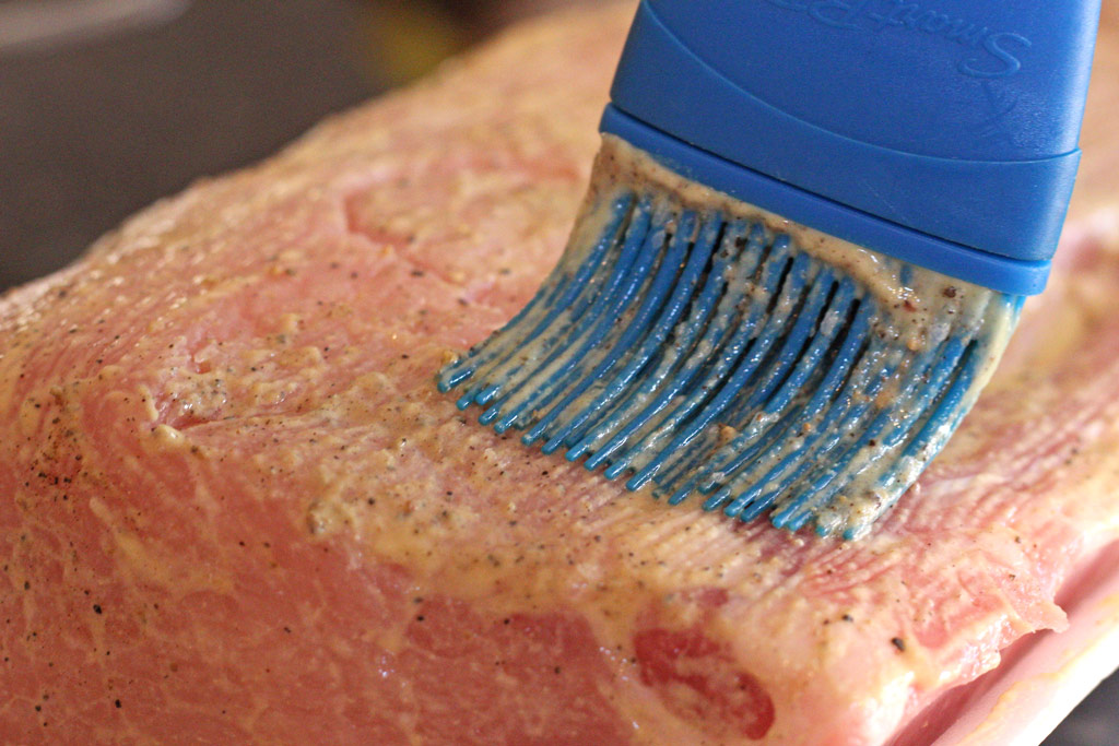 brushing the pork with mustard
