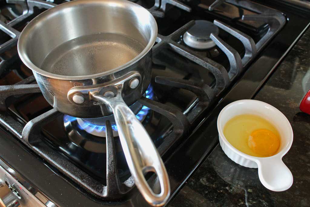 Pot on stove with egg in bowl