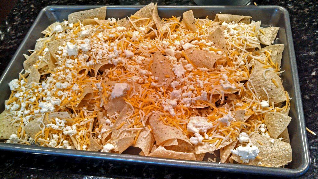 tortilla chips and cheese on a baking sheet