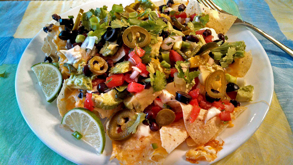 These vegetarian nachos can be made with tortilla chips covered in cheeses, black beans and any meatless toppings you choose. A quick, easy meatless meal! | TheMountainKitchen.com