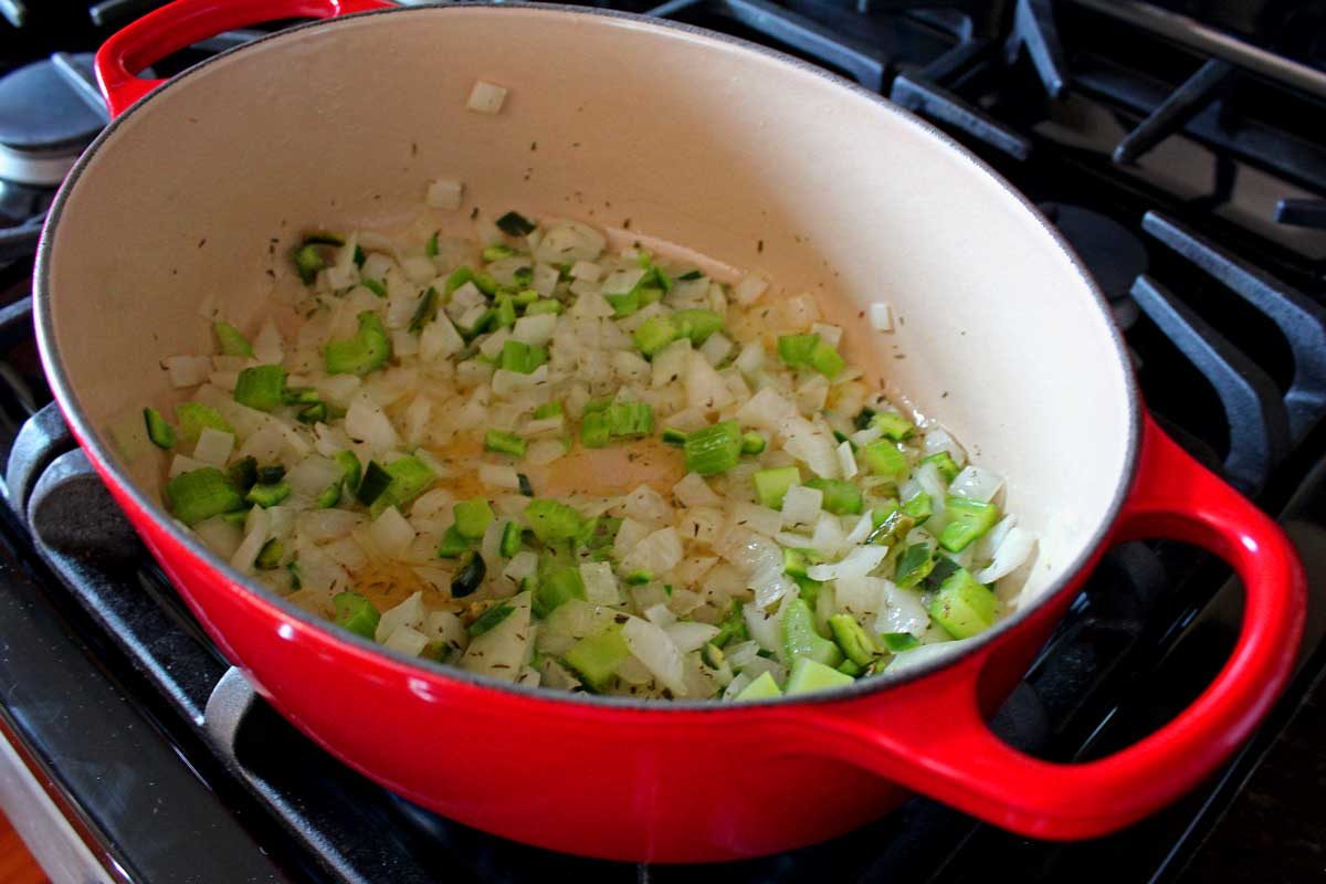 celery, onions, jalapenos, and thyme cooking in dutch oven