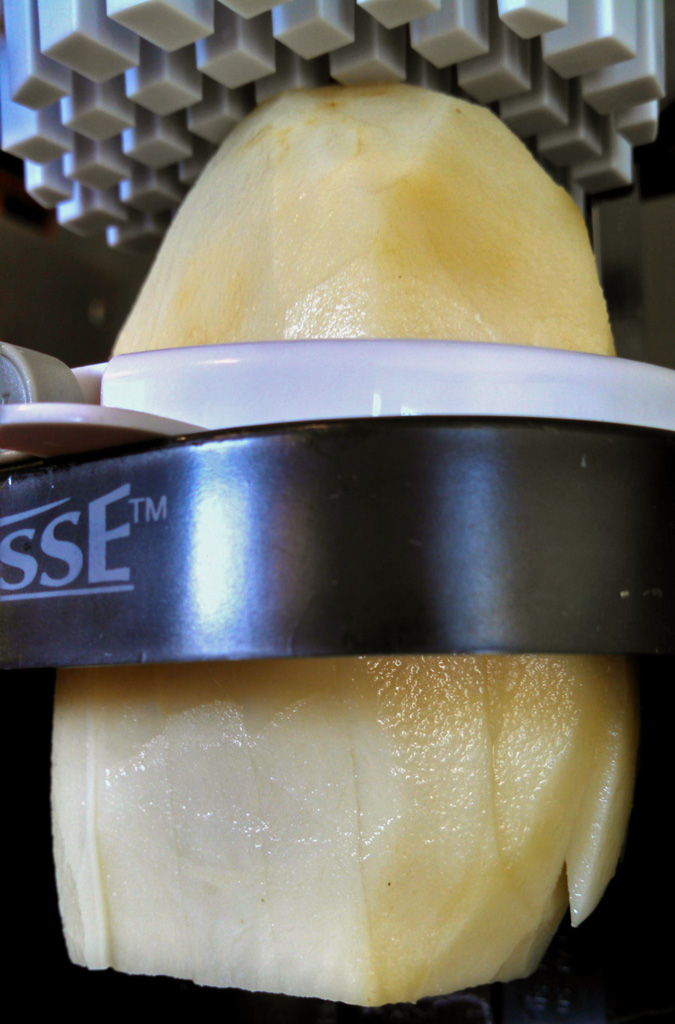 pressing potato through press