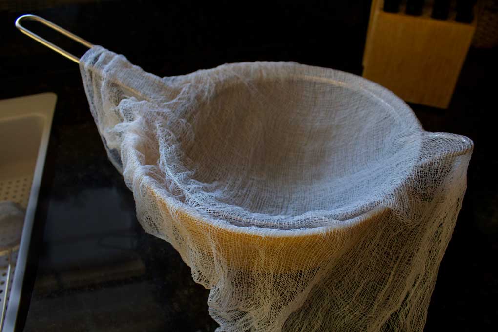 cheesecloth lined sieve in bowl