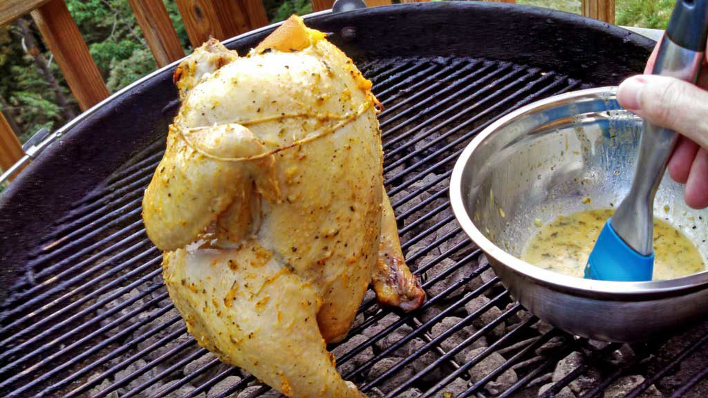 Beer Can Chicken is flavored with rosemary garlic orange butter sauce with garlic, slow cooked on the grill until tender, moist and falling-off-the-bone. | TheMountainKitchen.com