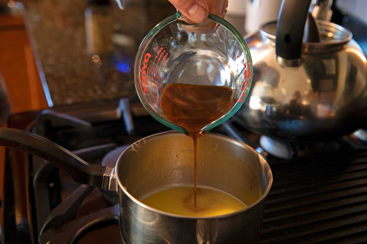 pouring Worcestershire sauce into pot 