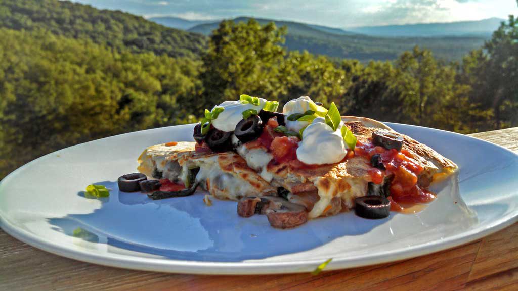 Spicy Pepper Jack Mushroom-Spinach Quesadilla on plate with mountain view