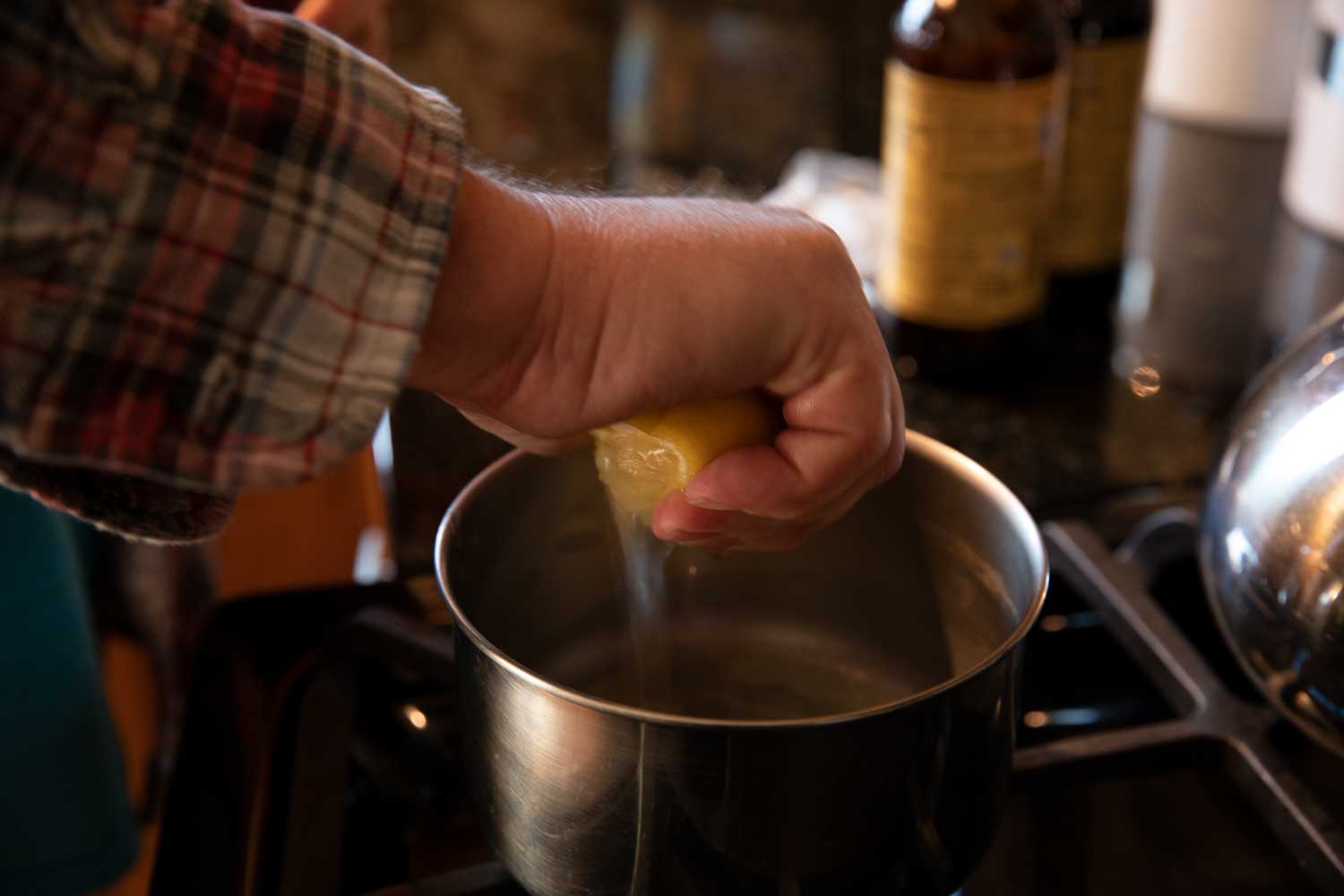squeezing lemon juice into pot