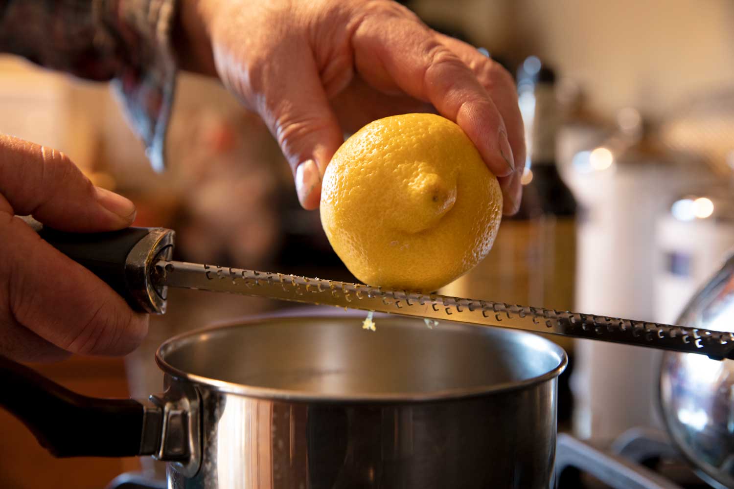 zesting lemon into sauce with microplane 