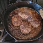 sizzle burgers frying in pan