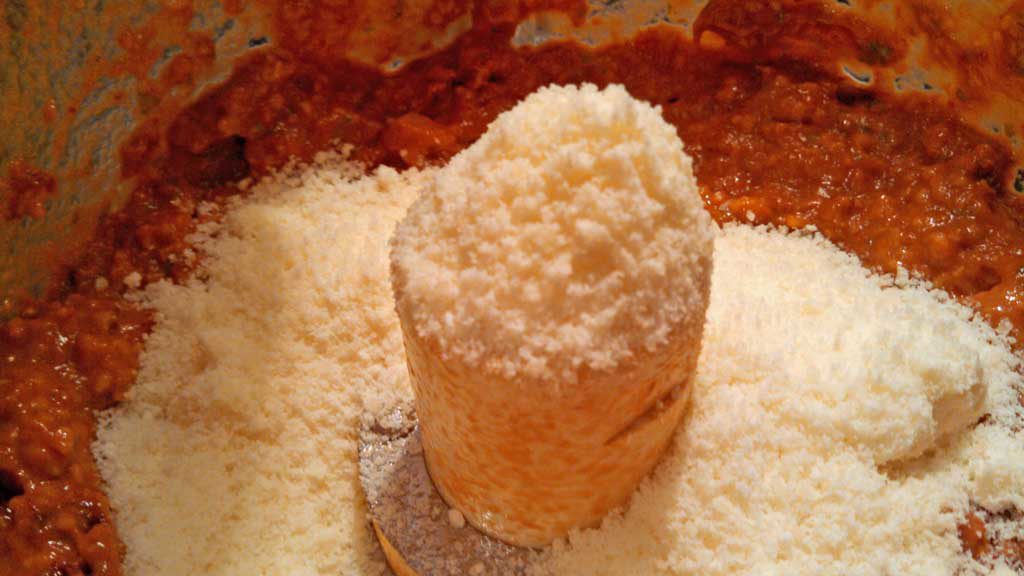 parmesan cheese added to sun-dried tomato pesto inside food processor
