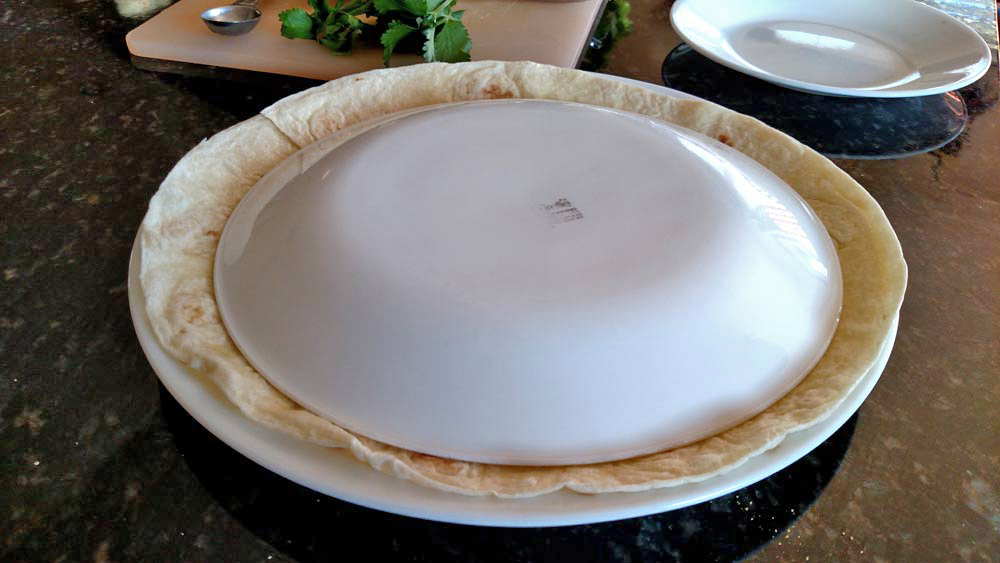 smaller plate on top of tortilla and larger plate