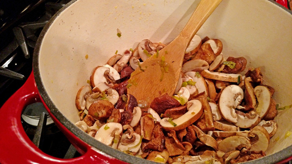 stirring mushrooms in pot