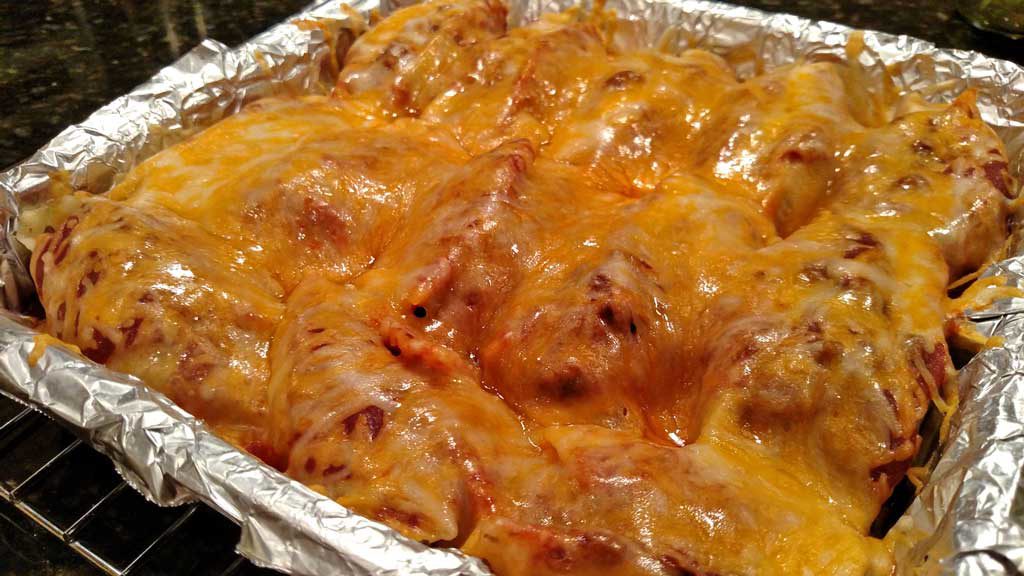 cheese covered pan of pasta enchiladas