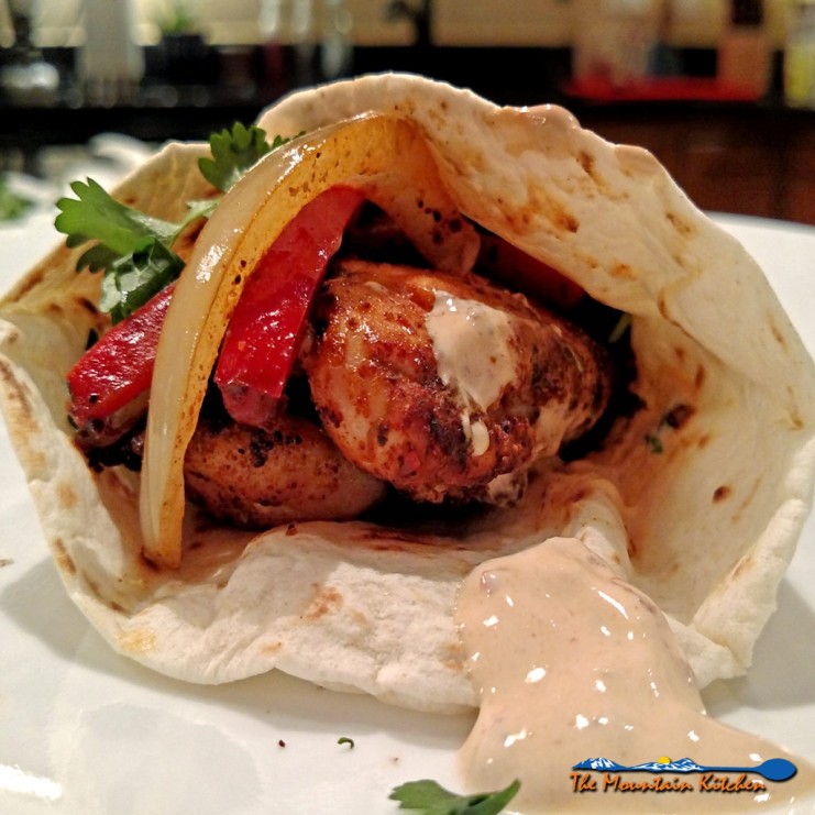 These easy weeknight chicken fajitas with seared chicken with Mexican spices served on a tortilla with chipotle sour cream, veggies, cheese and garnishes. | TheMountainKitchen.com