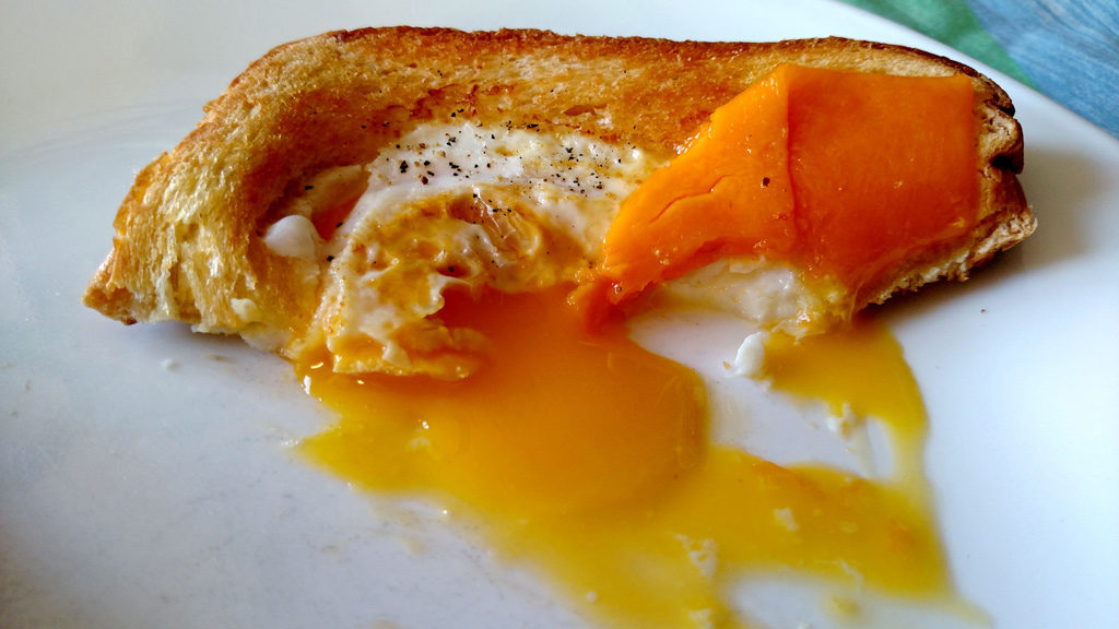 Eggs in a basket is a quick and easy breakfast, these eggs are fried inside a hole cut into a slice of bread and topped with melted cheese. | TheMountainKitchen.com
