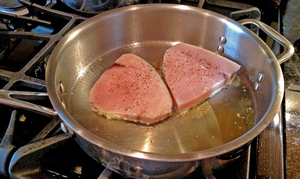 Sexy swordfish fillets smothered in a wonderful zesty sauce made of white wine, chicken broth, and garlic then finished off with lemon and fresh herbs. | TheMountainKitchen.com
