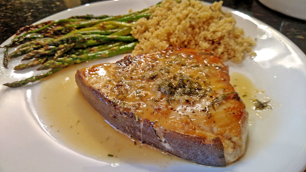 Sexy swordfish fillets smothered in a wonderful zesty sauce made of white wine, chicken broth, and garlic then finished off with lemon and fresh herbs. | TheMountainKitchen.com