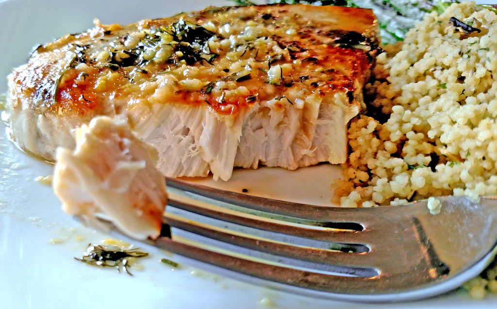 Sexy swordfish fillets smothered in a wonderful zesty sauce made of white wine, chicken broth, and garlic then finished off with lemon and fresh herbs. | TheMountainKitchen.com