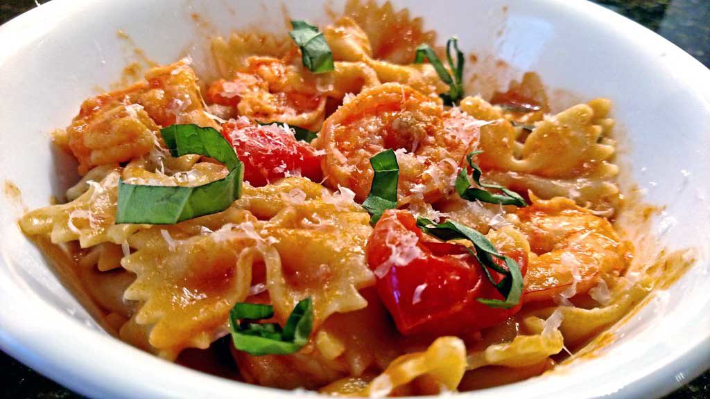 Basil, garlic, broth and tomato sauce all come together to create a delicious light sauce over Farfalle noodles and plump shrimp for this Shrimp Pomodoro. | TheMountainKitchen.com