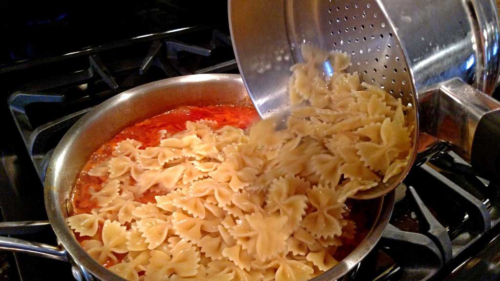 Basil, garlic, broth and tomato sauce all come together to create a delicious light sauce over Farfalle noodles and plump shrimp for this Shrimp Pomodoro. | TheMountainKitchen.com