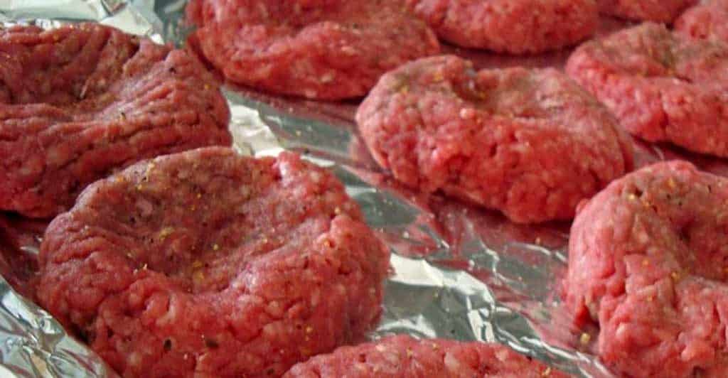 raw hamburger patties on tray