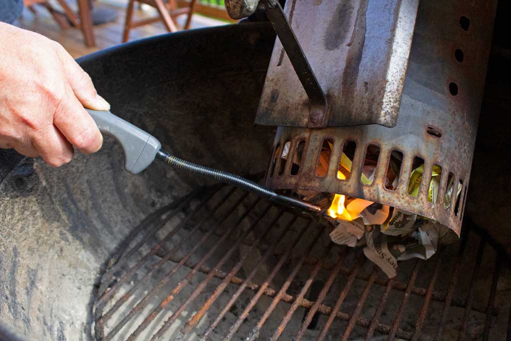 butane lighter lighting newspaper under chimney