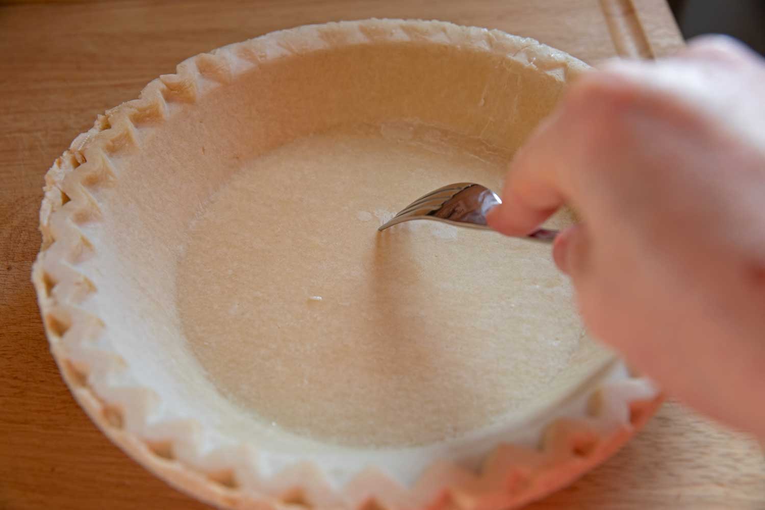 poking holes in raw crust with fork