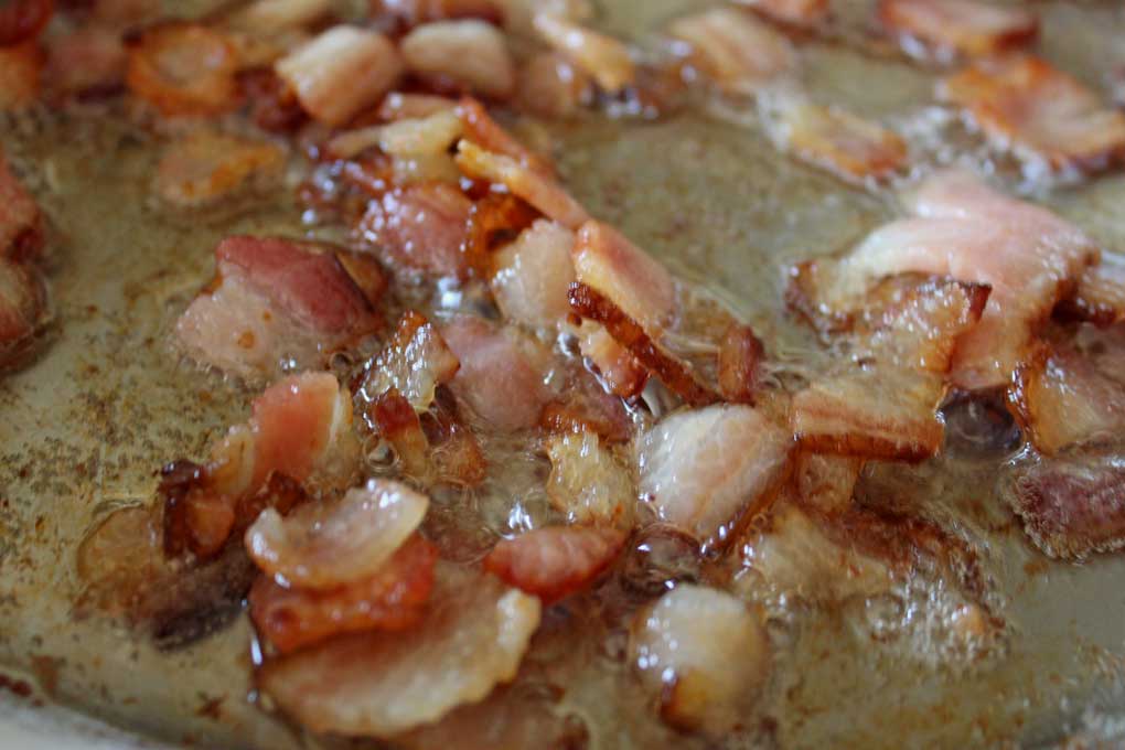 bacon bits cooking in pan