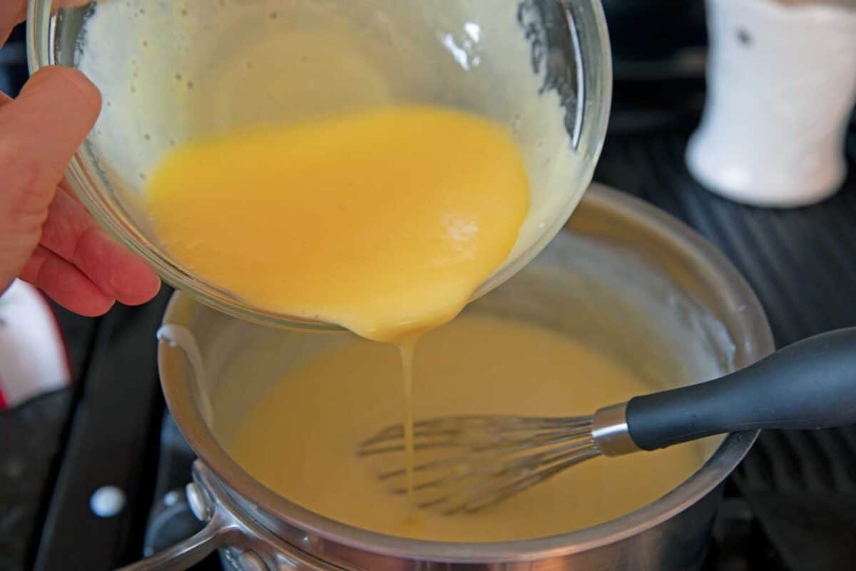 pouring tempered eggs into pot