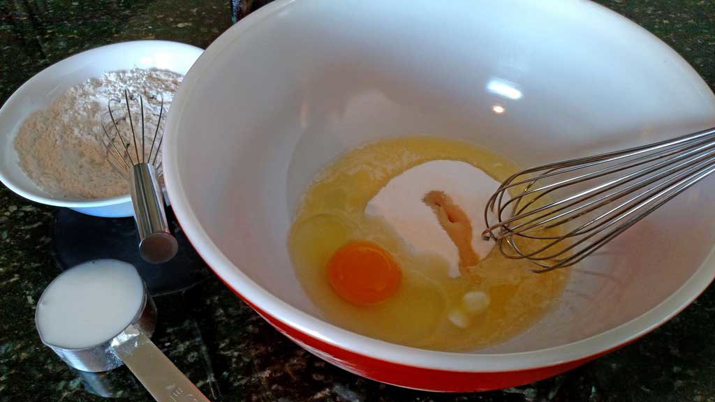 a mixing bowl with sugar and egg